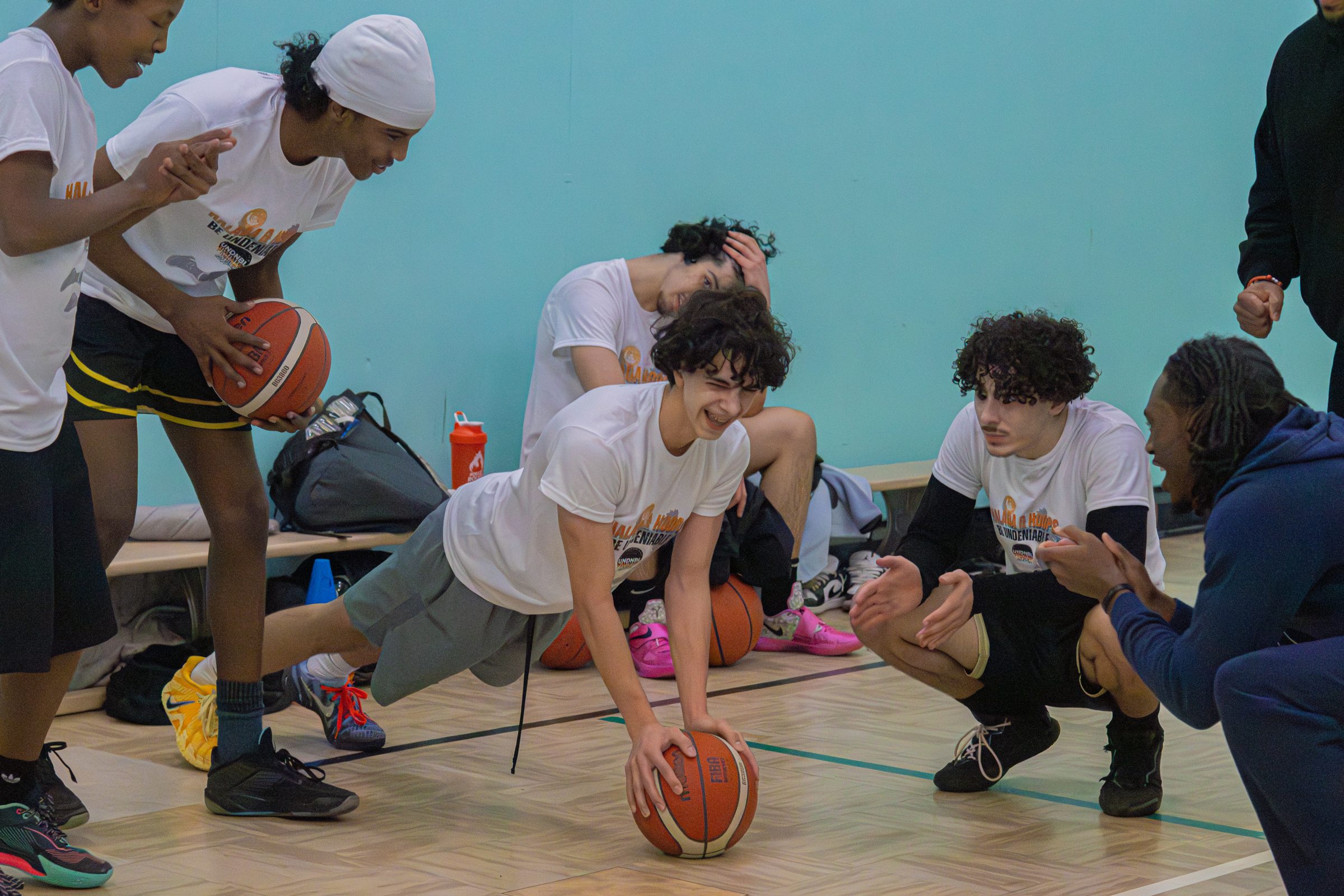 Players cheering on a teammate doing a basketball push-up drill